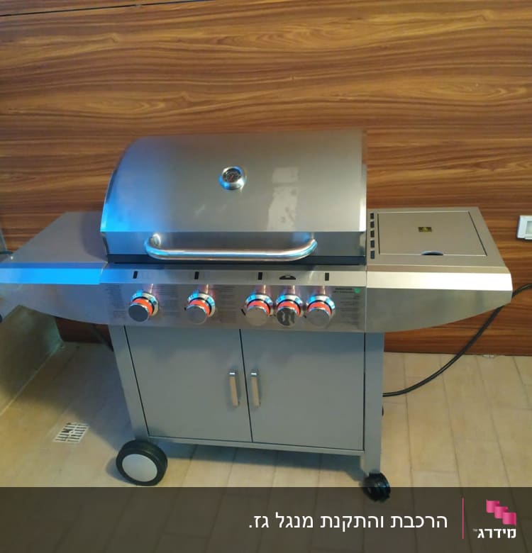 גריל גז מתכת עם ארבעה כפתורים ומכסה סגור